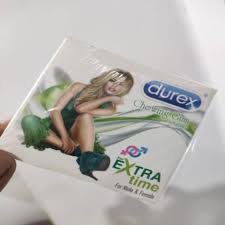 Hand holding Durex Extra Time chewing gum package with lime flavor, featuring green packaging design and "For Male & Female" text